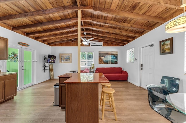 kitchen with lofted ceiling with beams, light wood-type flooring, wooden ceiling, plenty of natural light, and a kitchen island