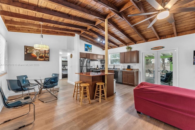 kitchen featuring wooden ceiling, a breakfast bar, beam ceiling, and appliances with stainless steel finishes