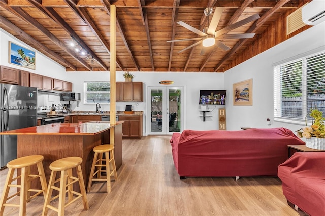 living area with ceiling fan, wood ceiling, beamed ceiling, and light wood-style floors