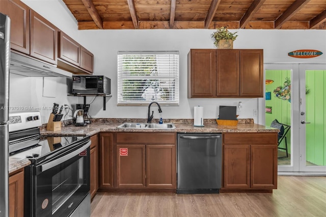 kitchen with light wood finished floors, a sink, beam ceiling, stainless steel appliances, and under cabinet range hood