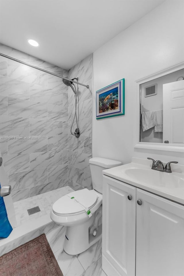 bathroom with toilet, a tile shower, visible vents, marble finish floor, and vanity