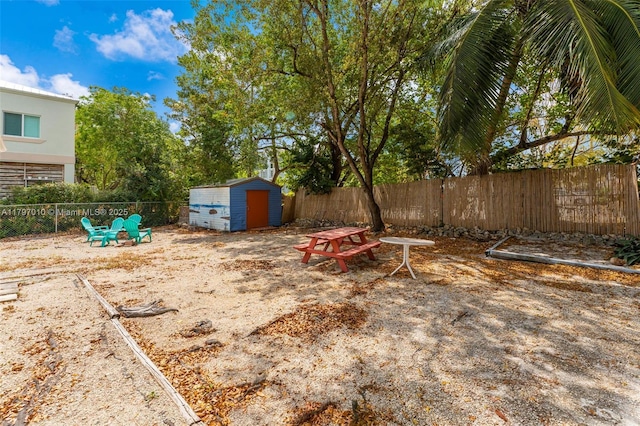 view of yard with an outbuilding, a fenced backyard, and a storage unit