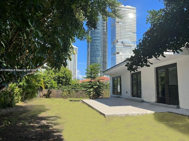 view of yard featuring fence, a patio, and french doors