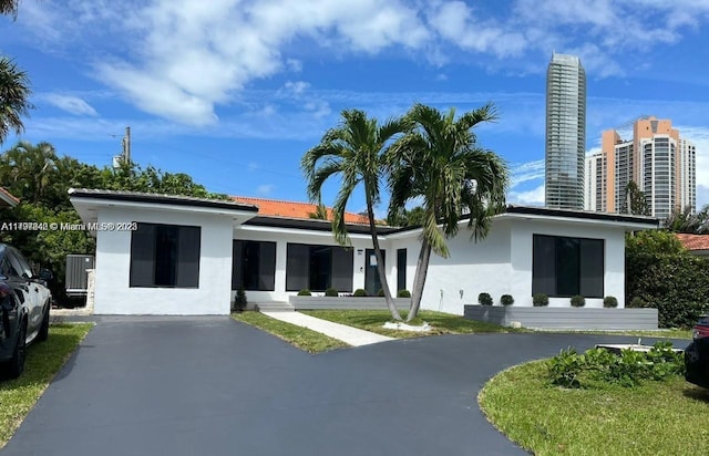 241 186th St, Sunny Isles Beach, FL 33160 - rear view of property featuring stucco siding and asphalt driveway