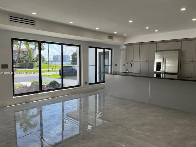 kitchen featuring a sink, gray cabinets, stainless steel fridge, and visible vents