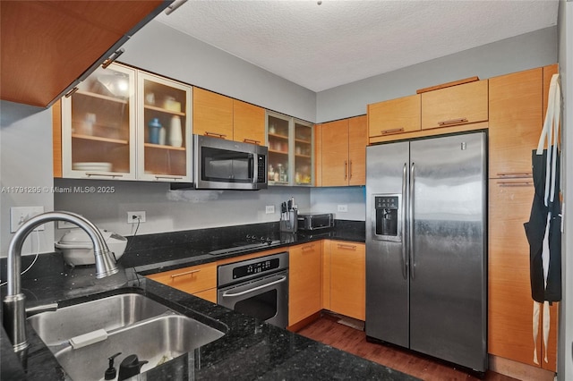31 SE 5th St Unit 1505, Miami, FL 33131 - kitchen featuring glass insert cabinets, dark wood finished floors, a sink, dark stone counters, and appliances with stainless steel finishes