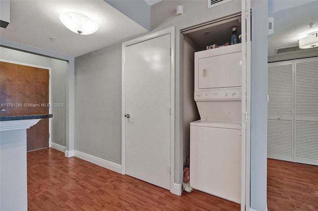 31 SE 5th St Unit 1505, Miami, FL 33131 - washroom with laundry area, stacked washer / dryer, wood finished floors, and baseboards