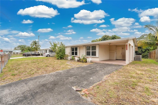 3460 NW 17th St, Lauderhill, FL 33311 - view of front of home featuring stucco siding, fence, central air condition unit, a front yard, and driveway