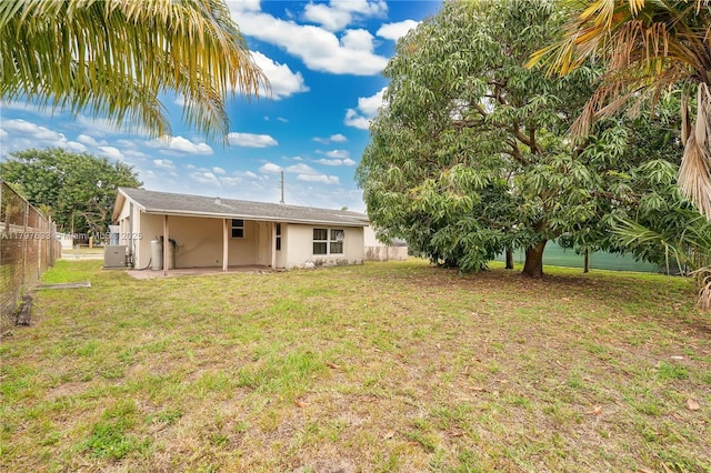 3460 NW 17th St, Lauderhill, FL 33311 - rear view of property featuring central AC, stucco siding, fence, a lawn, and a patio area