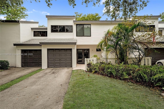 townhome / multi-family property featuring an attached garage, stucco siding, and driveway