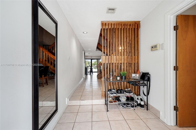 hall featuring light tile patterned flooring, visible vents, recessed lighting, stairway, and baseboards