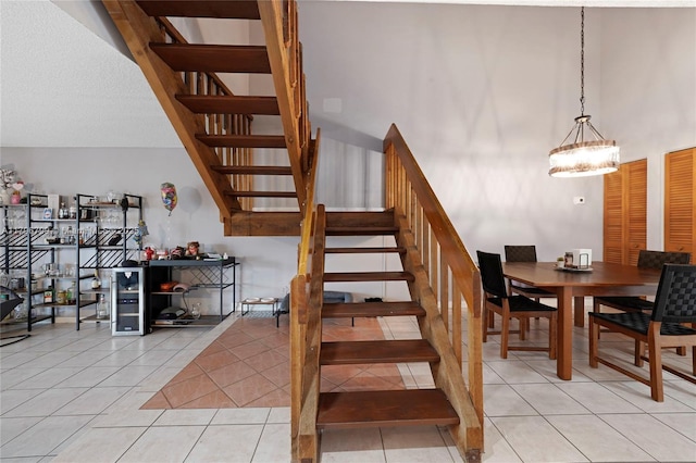 staircase featuring a notable chandelier and tile patterned flooring