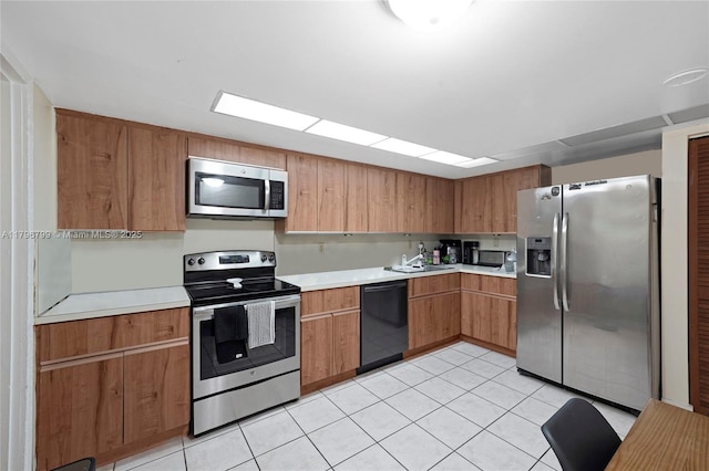 kitchen featuring light countertops, light tile patterned floors, stainless steel appliances, and a sink