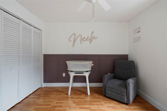 sitting room featuring light wood finished floors and ceiling fan