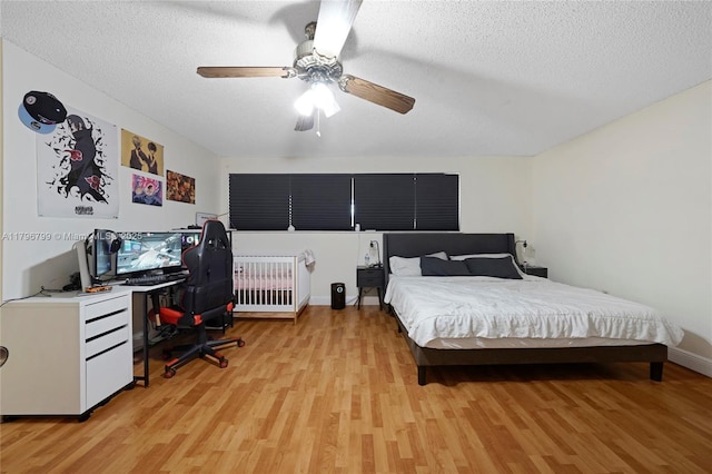 bedroom with radiator heating unit, light wood finished floors, ceiling fan, and a textured ceiling