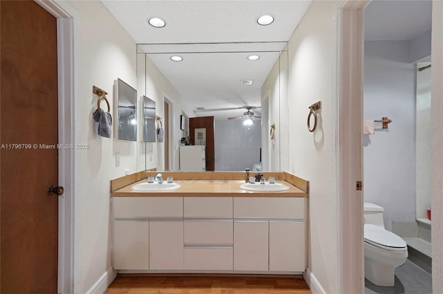 full bathroom with toilet, ceiling fan, a sink, and double vanity