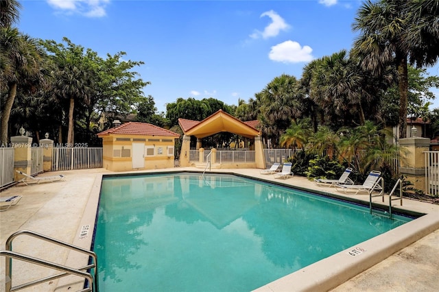 pool featuring a patio, fence, and a gazebo