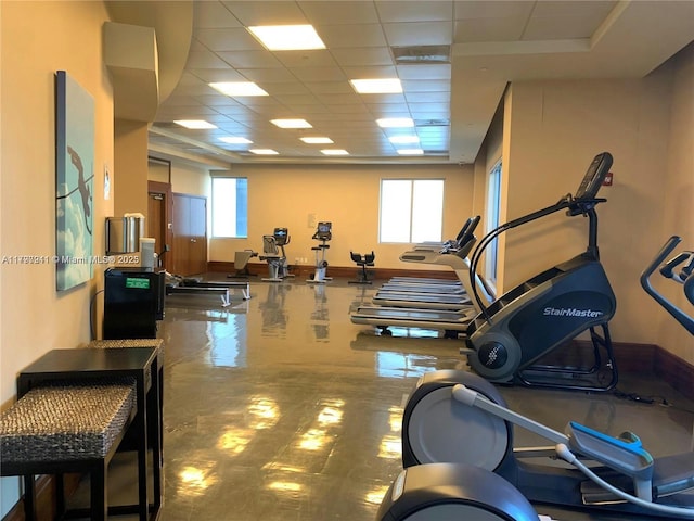 workout area featuring a drop ceiling and baseboards