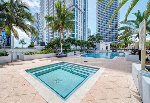 community pool with a patio and fence