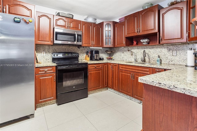 kitchen featuring backsplash, stainless steel appliances, light tile patterned floors, and a sink