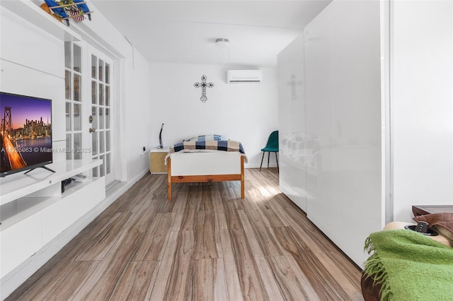 dining space featuring a wall mounted air conditioner, french doors, and wood finished floors