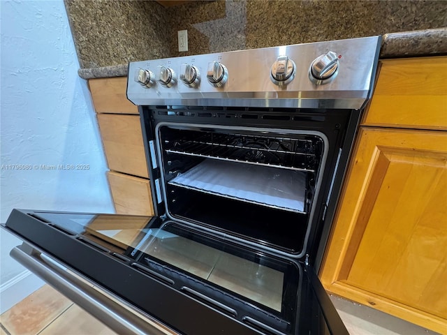 details with stainless steel stove, baseboards, and a textured wall