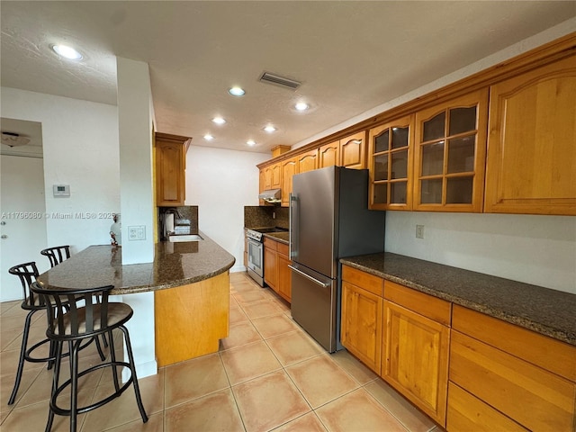 1700 Pierce St Unit 202, Hollywood, FL 33020 - kitchen with appliances with stainless steel finishes, a sink, a kitchen bar, brown cabinetry, and recessed lighting