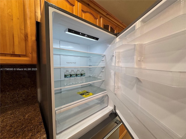 room details featuring brown cabinetry and refrigerator