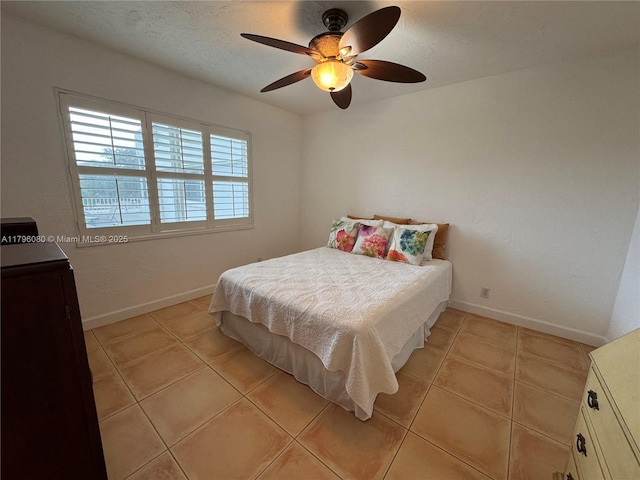 bedroom featuring ceiling fan, baseboards, and light tile patterned floors