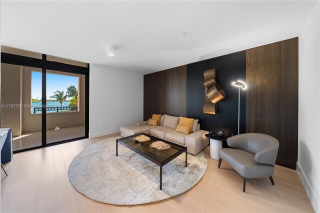 7025 Fisher Island Dr Unit 7025, Miami Beach, FL 33109 - living area featuring an accent wall, light wood-type flooring, and baseboards