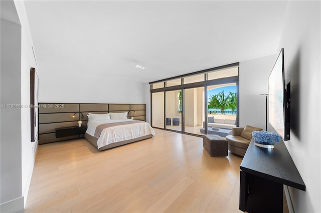 7025 Fisher Island Dr Unit 7025, Miami Beach, FL 33109 - bedroom with access to exterior, wood finished floors, and a wall of windows