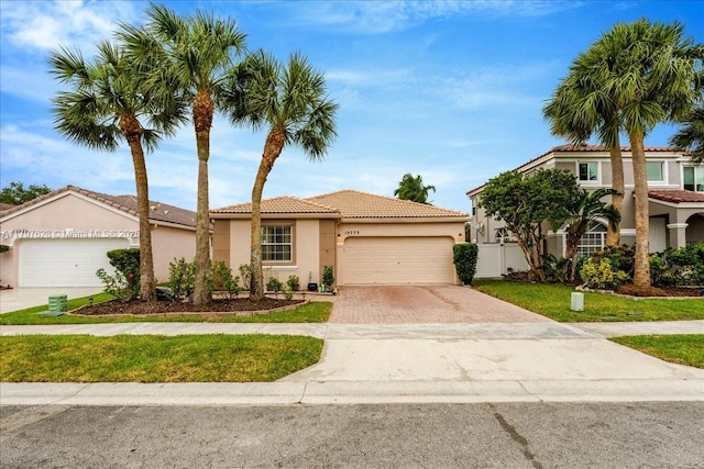 view of front of property featuring a garage, stucco siding, a tiled roof, and driveway