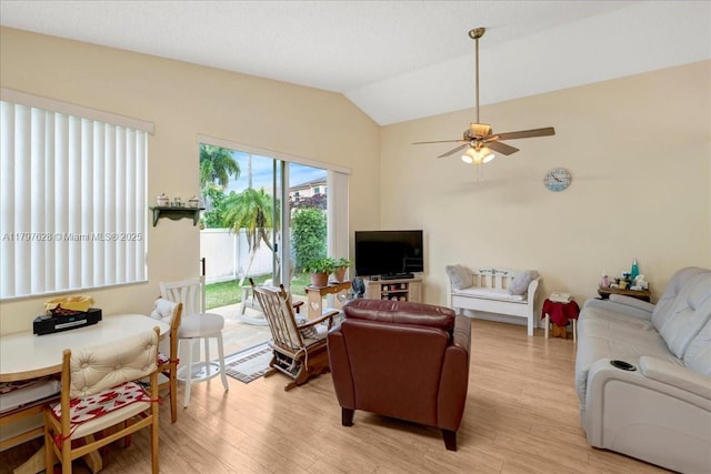 living room with vaulted ceiling, light wood finished floors, and a ceiling fan