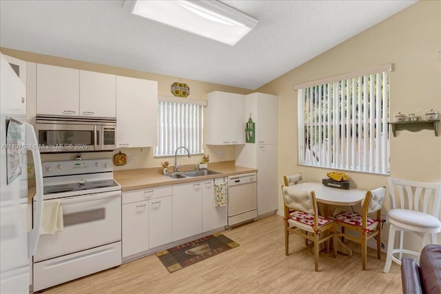 kitchen featuring a sink, white cabinets, light wood-type flooring, white appliances, and light countertops