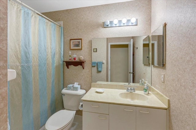 full bath with toilet, vanity, and curtained shower
