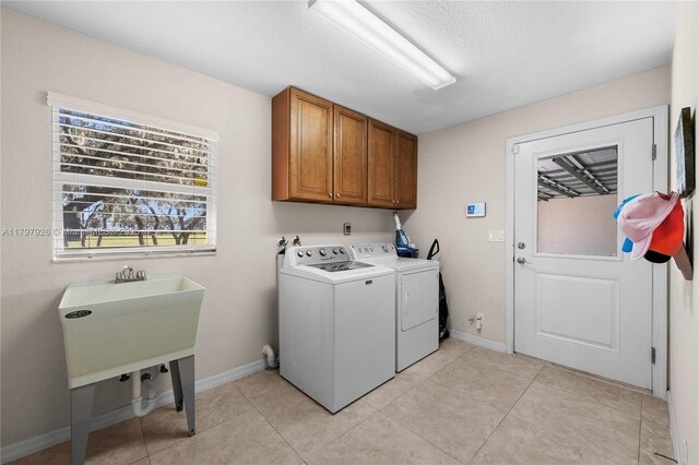 2650 Scrubpens Rd, Sebring, FL 33870 - washroom with washer and dryer, cabinet space, baseboards, and light tile patterned flooring