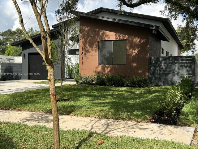 1611 SW 30th Ave, Fort Lauderdale, FL 33312 - view of home's exterior featuring a lawn, driveway, concrete block siding, and an attached garage