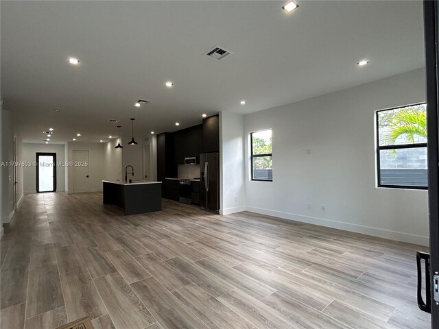1611 SW 30th Ave, Fort Lauderdale, FL 33312 - kitchen featuring visible vents, a center island with sink, open floor plan, baseboards, and appliances with stainless steel finishes