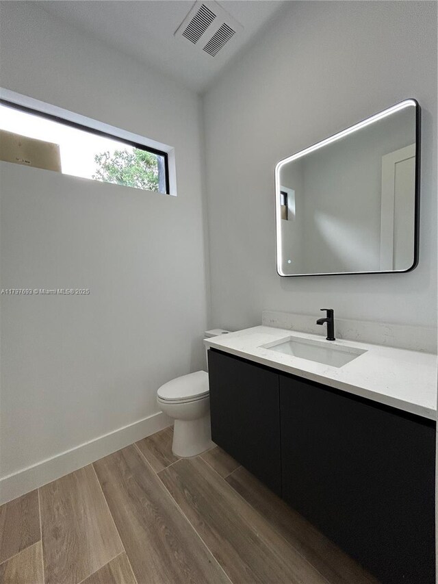 1611 SW 30th Ave, Fort Lauderdale, FL 33312 - half bath featuring vanity, toilet, visible vents, and wood finished floors