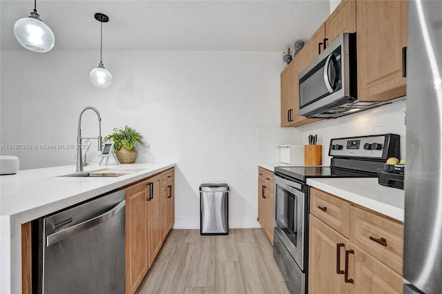 kitchen featuring a sink, a peninsula, tasteful backsplash, light countertops, and appliances with stainless steel finishes