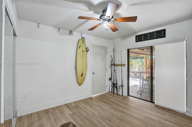 unfurnished room featuring a textured ceiling, wood finished floors, and ceiling fan