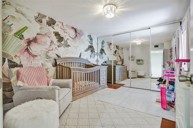 bedroom with a closet, wallpapered walls, and visible vents