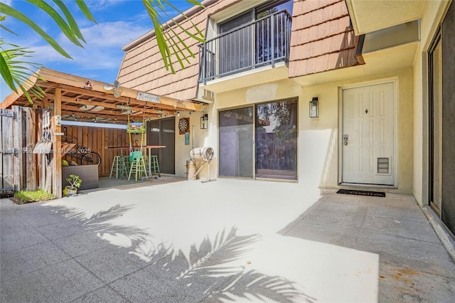 9136A SW 20th Pl, Davie, FL 33324 - entrance to property with stucco siding, a patio, a balcony, and mansard roof