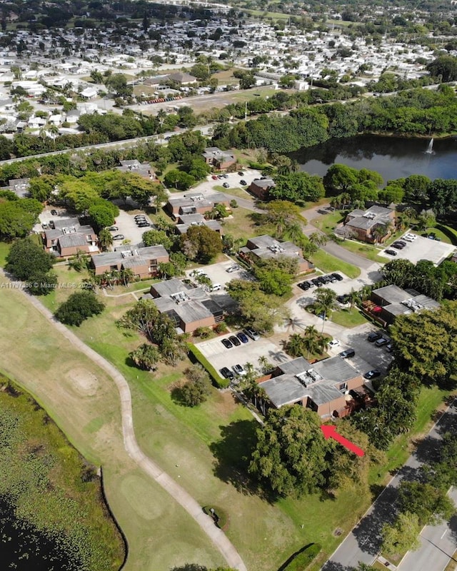 drone / aerial view with a water view, golf course view, and a residential view