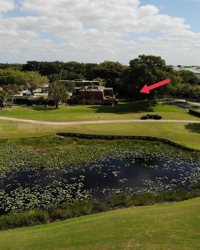 surrounding community featuring a water view, a yard, and golf course view