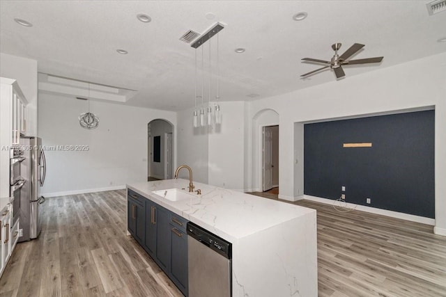 12471 NW 78th Mnr, Parkland, FL 33076 - kitchen featuring a sink, arched walkways, appliances with stainless steel finishes, ceiling fan, and light wood-style flooring