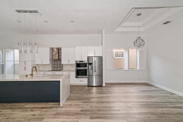 12471 NW 78th Mnr, Parkland, FL 33076 - kitchen featuring stainless steel appliances, wall chimney exhaust hood, a sink, baseboards, and light wood-style floors