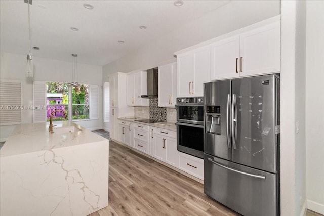 12471 NW 78th Mnr, Parkland, FL 33076 - kitchen with appliances with stainless steel finishes, wall chimney range hood, a sink, white cabinetry, and light wood-type flooring