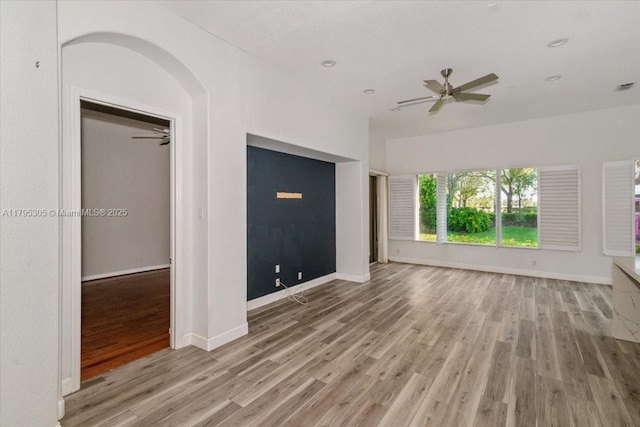 12471 NW 78th Mnr, Parkland, FL 33076 - unfurnished living room with wood finished floors, ceiling fan, arched walkways, baseboards, and recessed lighting