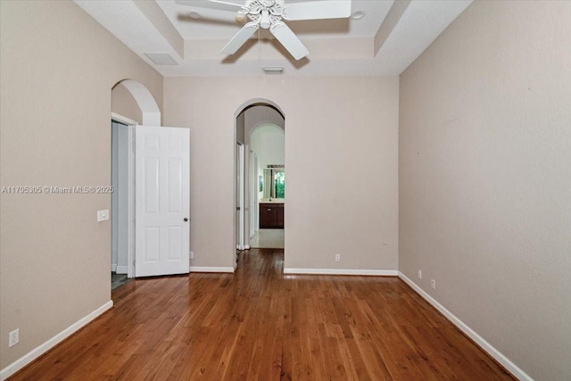 12471 NW 78th Mnr, Parkland, FL 33076 - spare room with a raised ceiling, wood finished floors, arched walkways, and ceiling fan
